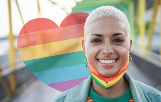 Happy woman wearing LGBTQ rainbow flag pride mask