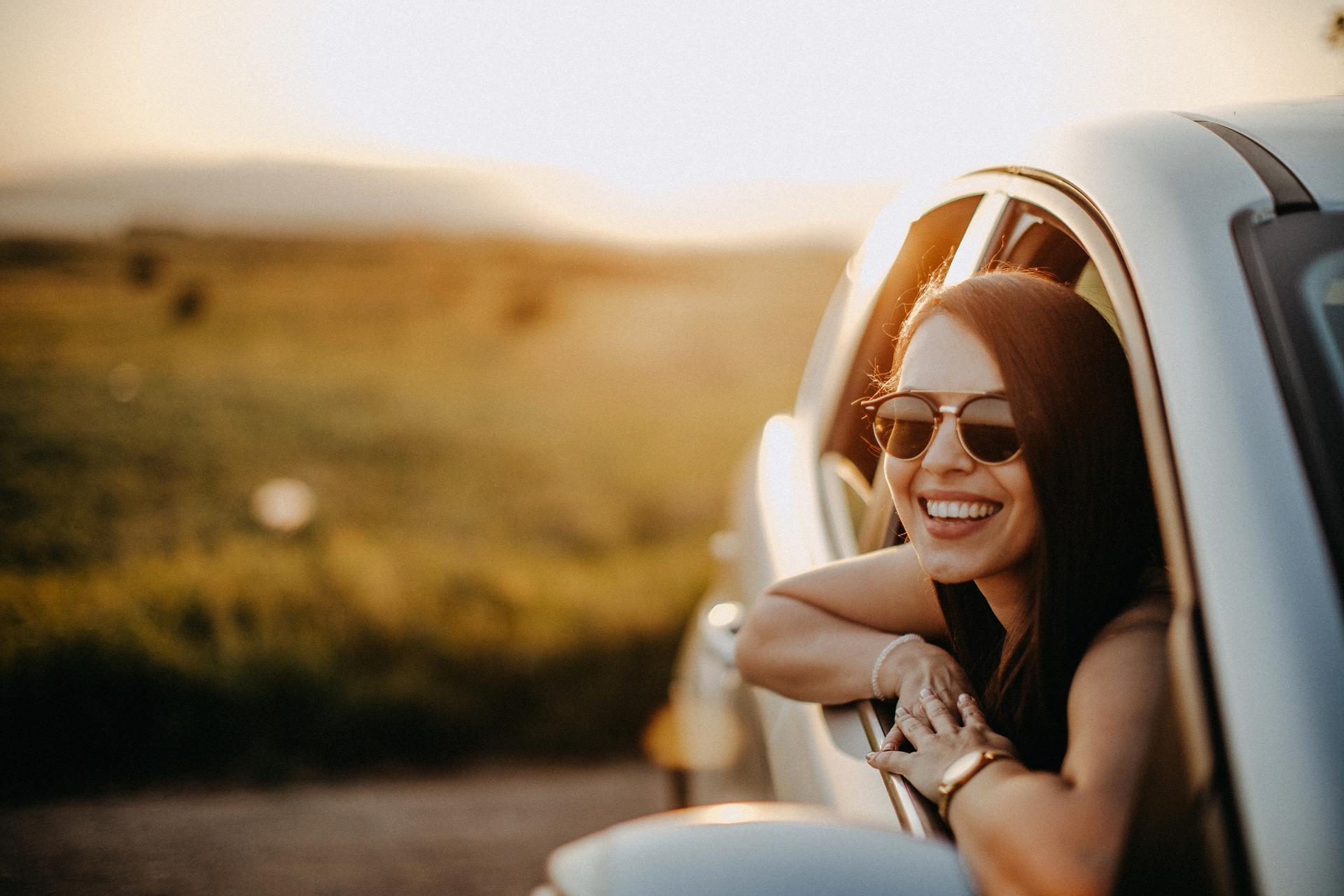 A smiling woman in her car.