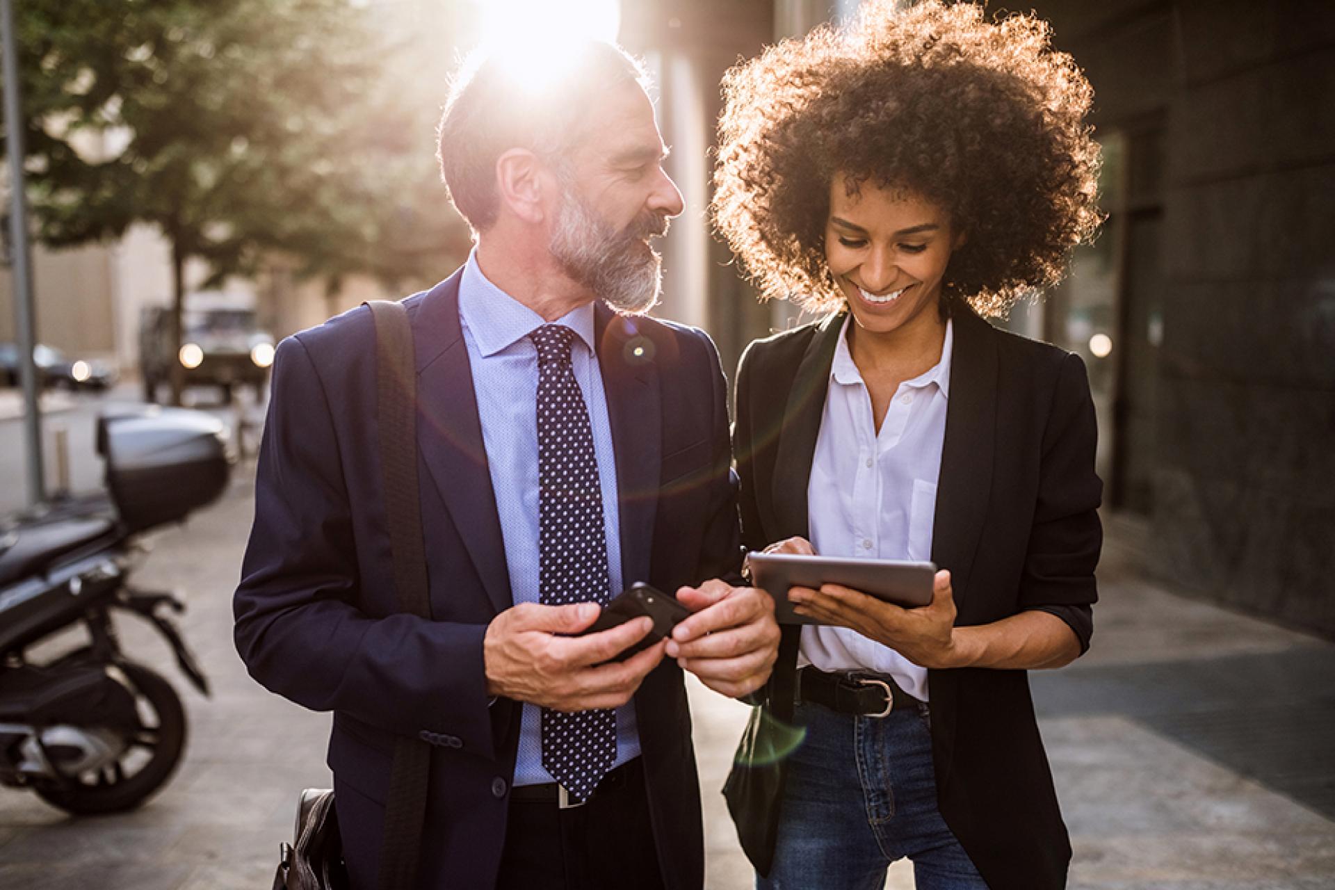 A man and woman looking at a tablet.