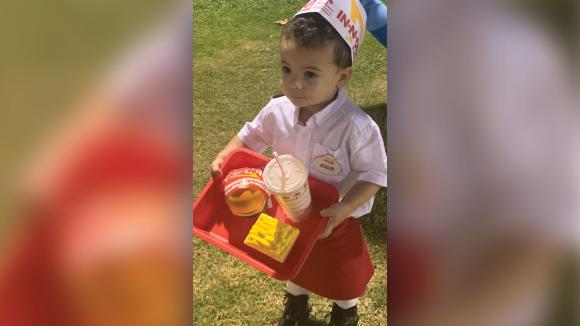 A boy dressed up in the uniform of a fast food restaurant