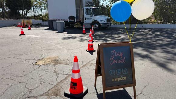 Signage with balloons, the shred truck can be seen in the back