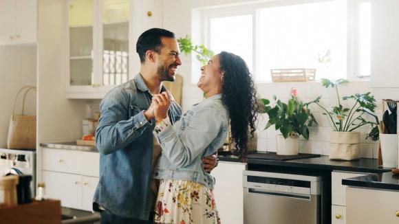Two people dancing in a kitchen