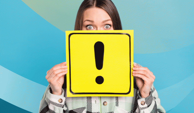 Person holding a yellow sign displaying a big exclamation point