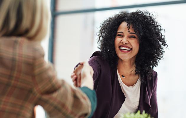 Two women shaking hands.