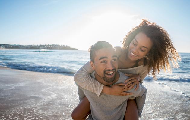 Couple on beach piggy back