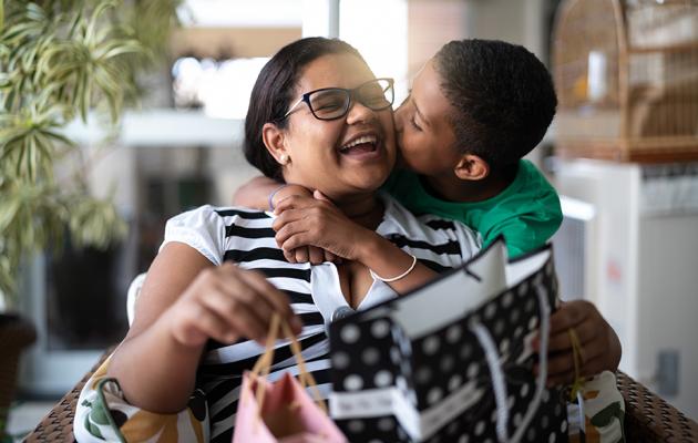 Son kissing his mom on the cheek.
