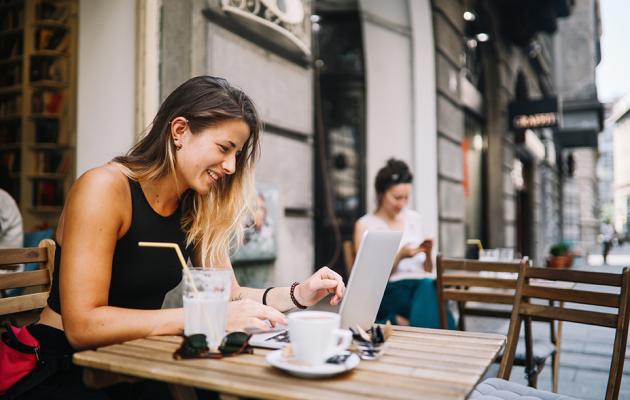 Woman sitting at a table looking at computer