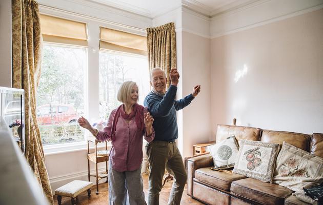 Senior couple dancing in living room