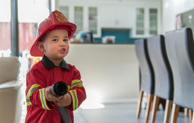 A boy in a fireman costume.