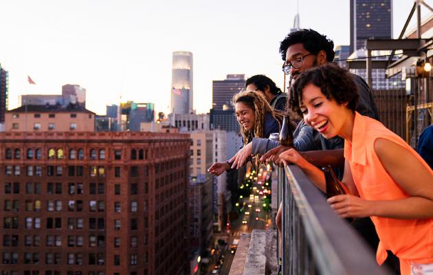 Party group overlooking city from rooftop