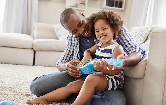 Father and young daughter playing baby guitar