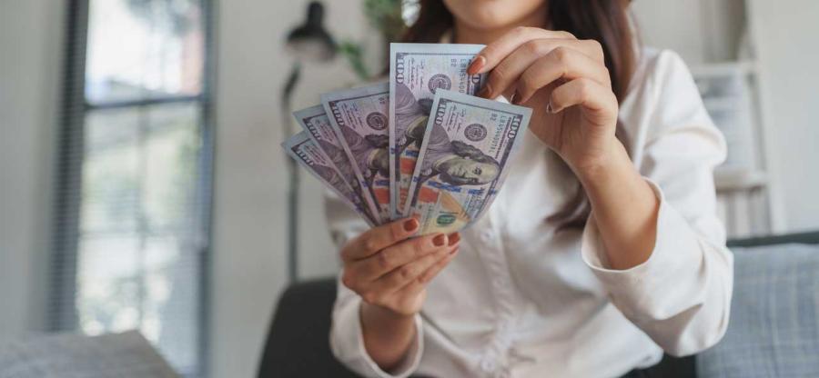 Person holding dollar bills.