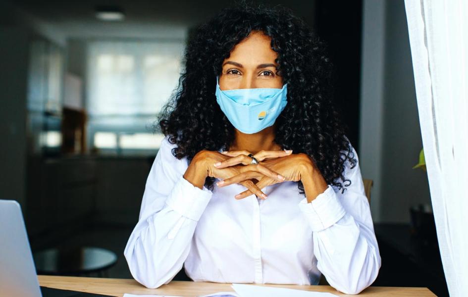 A woman with a face mask looking at the camera. 