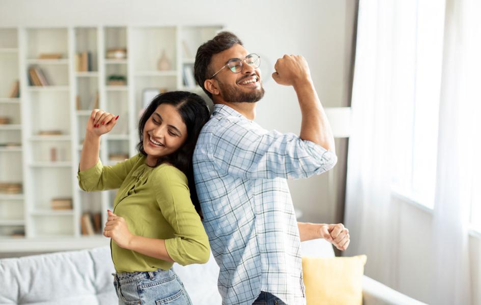 Two people dancing in their living room.