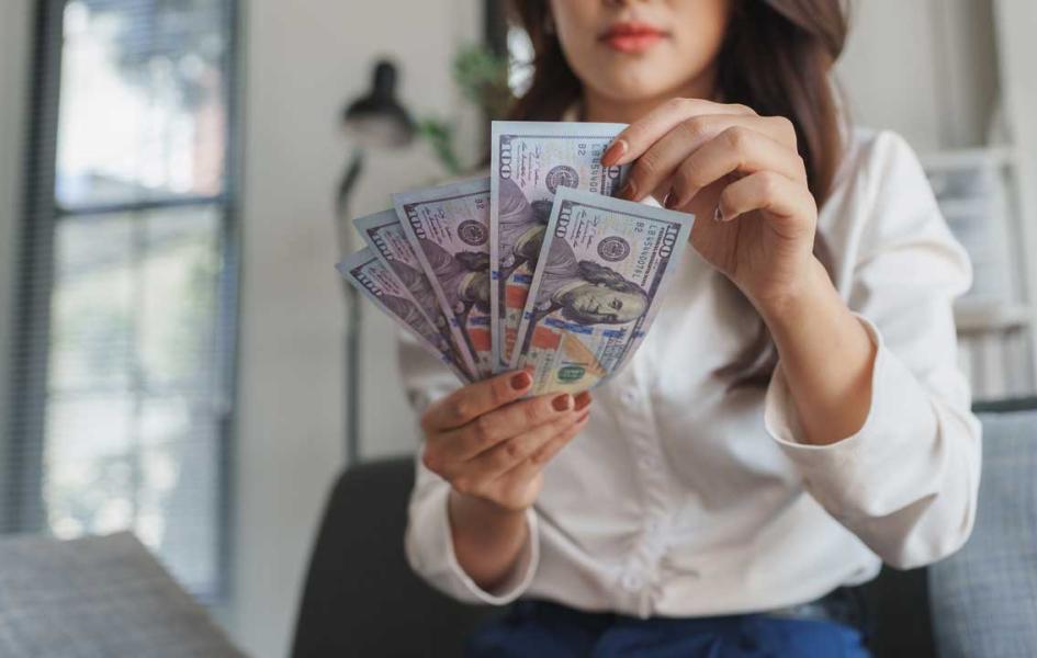 Person holding dollar bills.