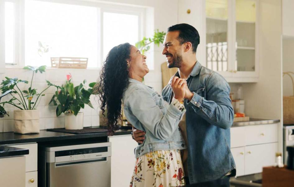 Two people dancing in a kitchen