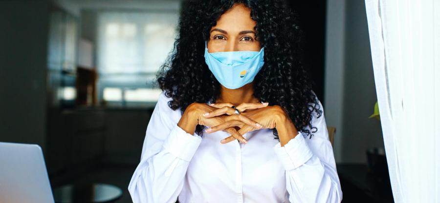 A woman with a face mask looking at the camera. 