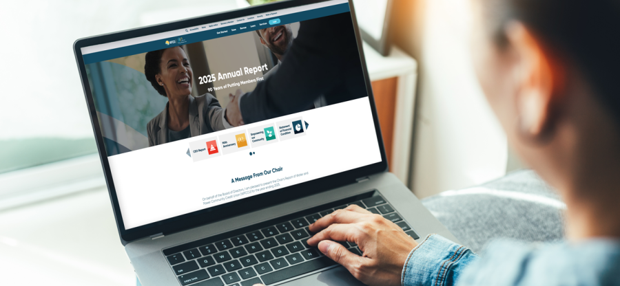 Person with a laptop, the computer screen displays WPCCU's 2025 Annual Report.