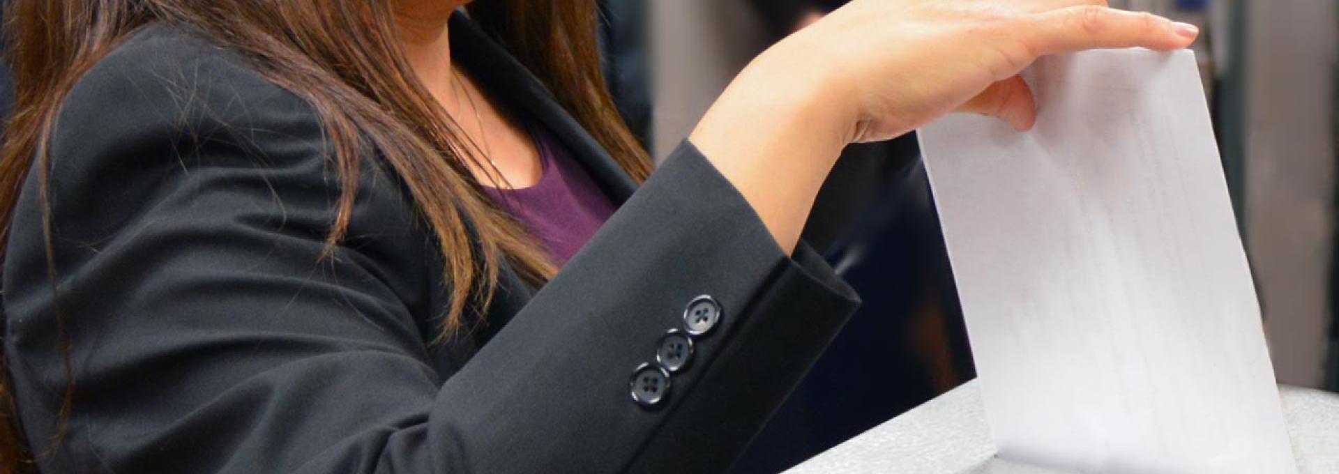 A woman is casting a ballot.