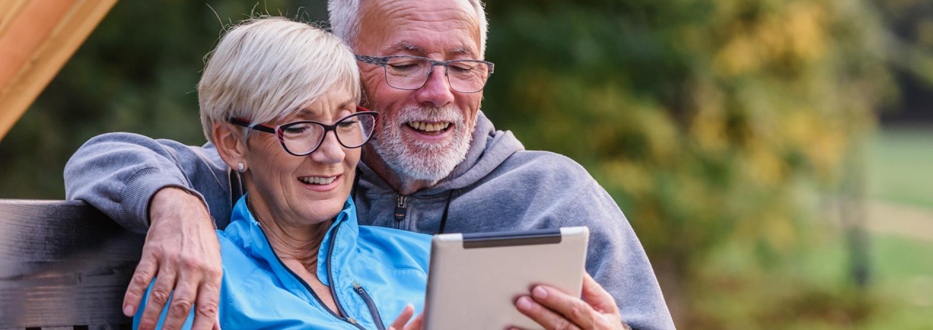 Couple reading together on a tablet.