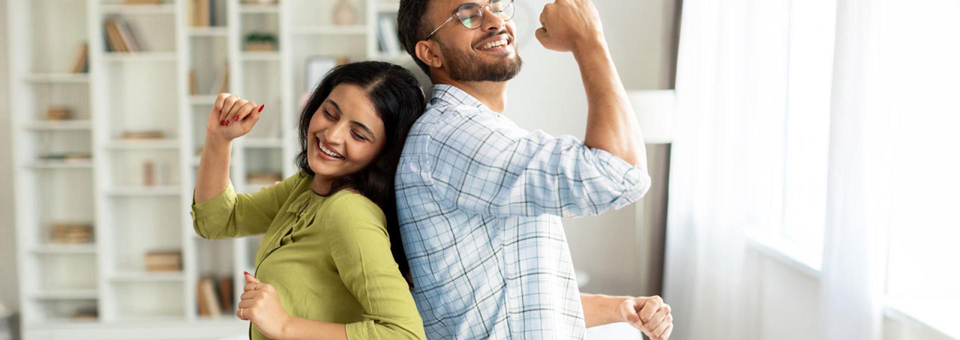 Two people dancing in their living room.