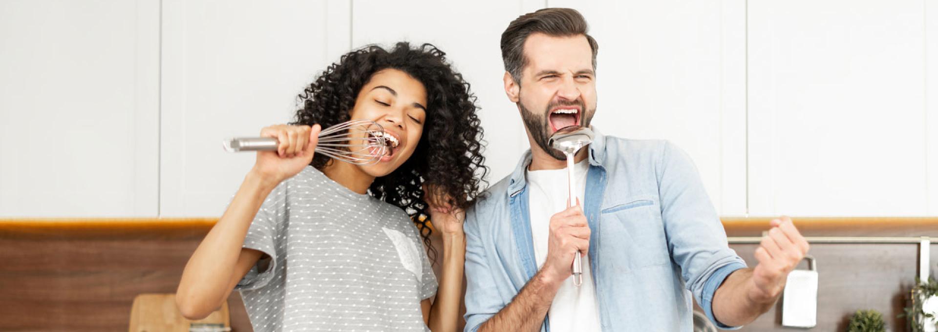 Two people singing in their kitchen